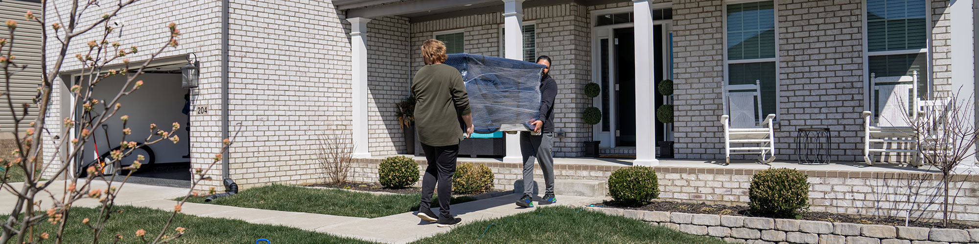 People Moving Items Into House